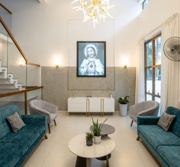 A cozy living room featuring a blue couch and a white table, creating a modern and inviting atmosphere.