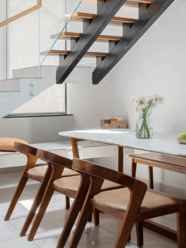 A modern dining room featuring a wooden table surrounded by stylish wooden chairs.