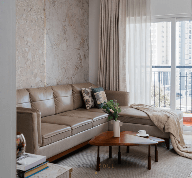 A cozy living room featuring a couch, coffee table, and a large window letting in natural light.